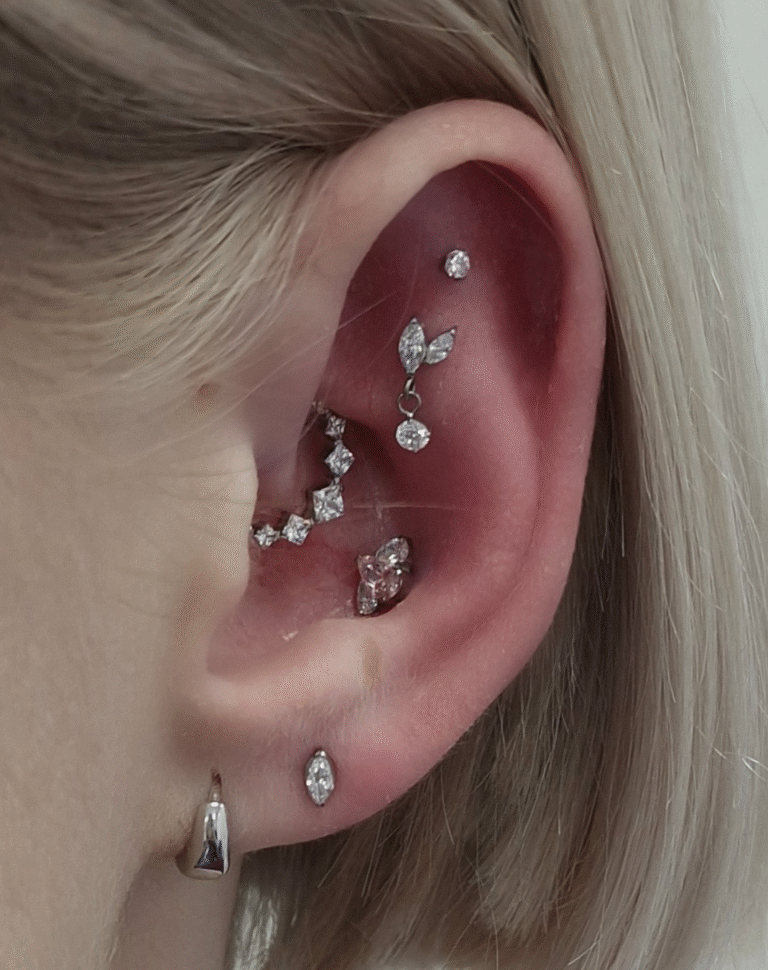 An ear with many detailed earrings